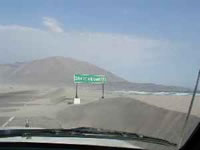 Media calzada de la ruta panamericana, virtualmente "tapada" de arena. Curioso cartel de "Zona de Arenamiento".